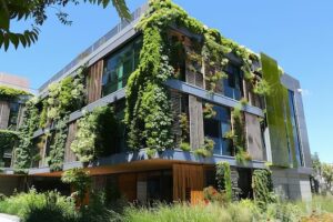 Edifício moderno com elementos de arquitetura verde, como fachada vegetal, representando a sustentabilidade na construção civil em 2025. Imagem gerada com IA